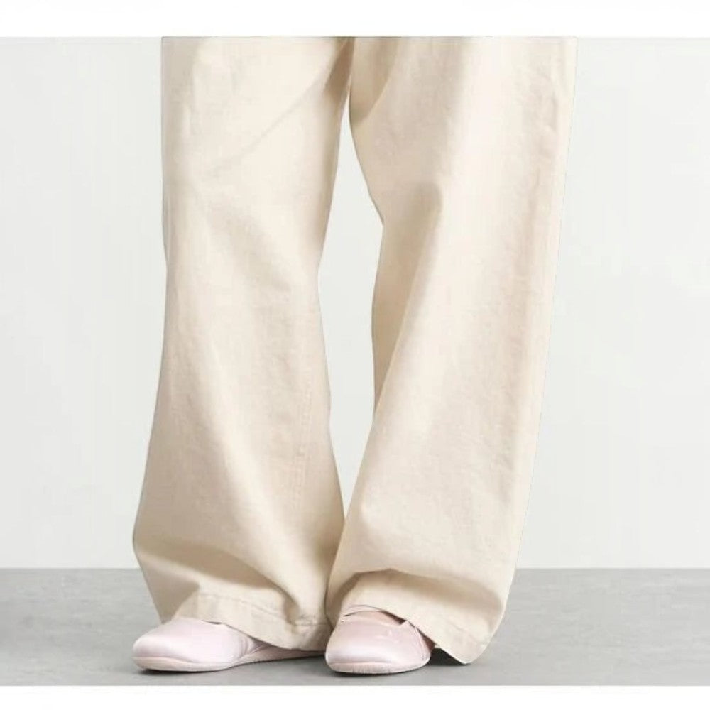 Luxurykicks.store PUMA Speedcat Ballet Venus sneakers in soft pink worn with wide-leg beige trousers