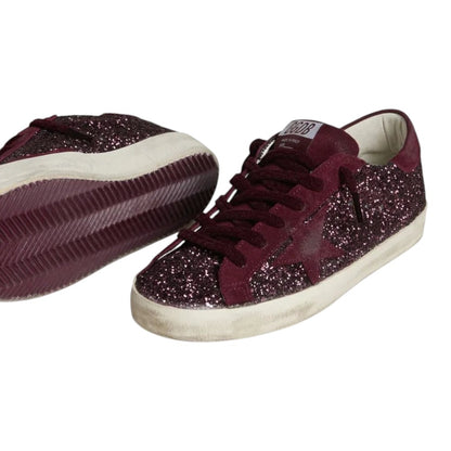 Luxurykicks.store Golden Goose Super-Star sneakers in cherry red glitter with signature distressed rubber soles.