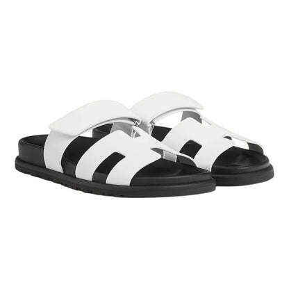 Luxurykicks.store Hermes Chypre sandals in white leather with a black sole and adjustable hook-and-loop strap