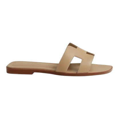 Luxurykicks.store Hermes Oran sandal in beige leather with signature H cut-out design, side view.