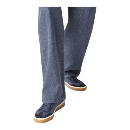 Luxurykicks.store Loro Piana Tennis Walk sneakers in blue with a gum sole, worn with wide-leg denim trousers.